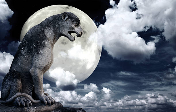 istock Ancient lion statue and bright moon in the night sky 619768980