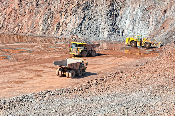 istock earthmover loading a dumper truck with stone material 619768986
