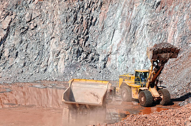 istock earthmover loading a dumper truck with stone material 619769282
