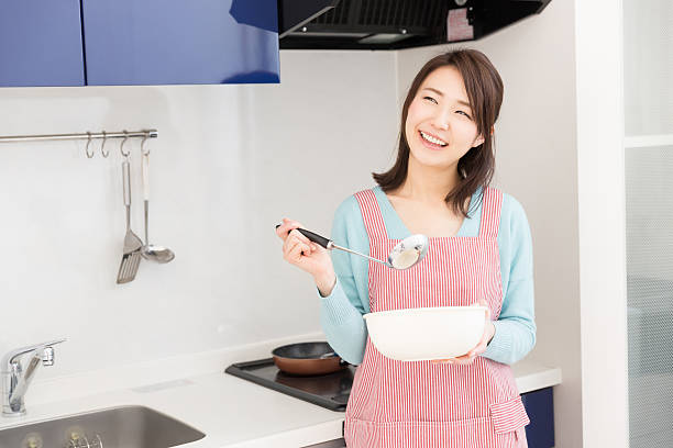 Relaxed happy mature woman having a healthy vegetarian meal in the kitchen. Woman eating fresh fruits salad at home. Lunch, breakfast or snack for health and wellness