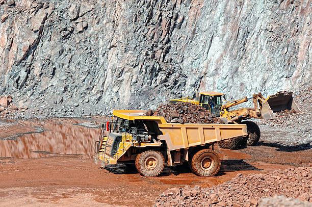 istock earthmover loading a dumper truck with stone material 619769490