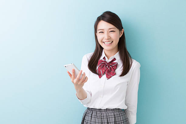 istock Schoolgirl using a smartphone 619769622