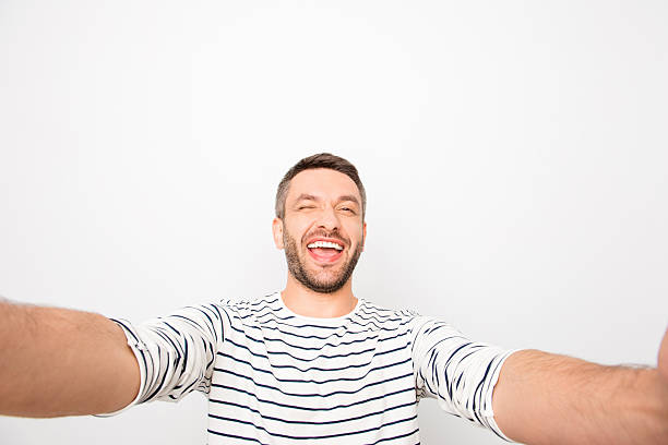 istock Cheerful happy smiling man making selfie and winking 619771792