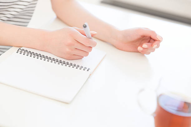 istock Japanese woman writing in a notebook 619961596