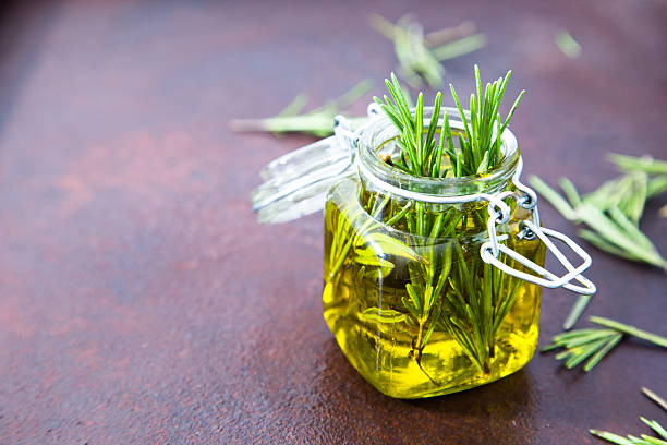 rosmarinöl. rosmarin ätherisches öl glas glas flasche und zweig - rosemary stock-fotos und bilder