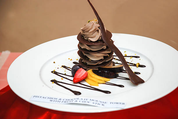 Pistachios and chocolate mousse tower with fruit and choc stick