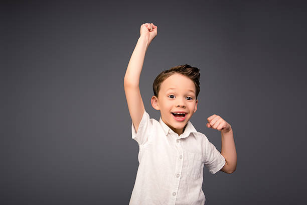istock Yes!  Happy little boy triumphing with raised hands 619964700