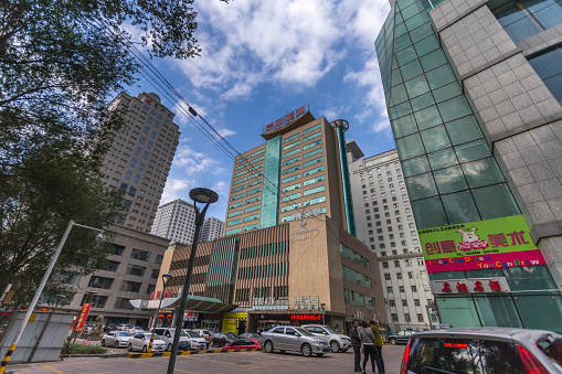 Urumqi, Xinjiang, China - October 4, 2016: Urumqi street view. Bus and Taxi on the road, business buildings on the road sides, incidental people on the background.