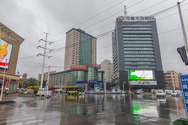 Urumqi, Xinjiang, China - October 14, 2016: Urumqi downtown street view. Office buildings on the background, Cars and incidental people at front.
