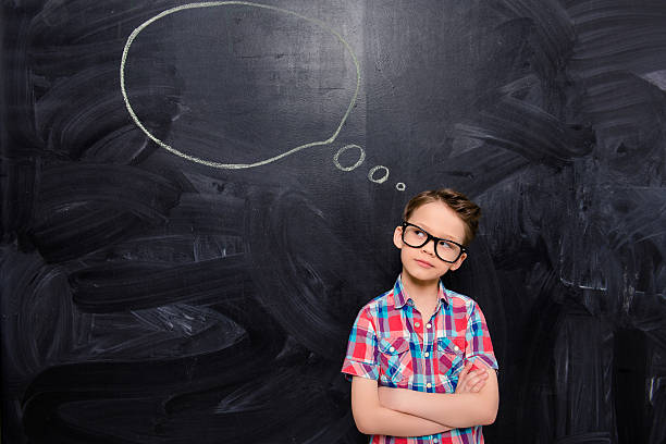 istock Portrait of young boy in glasses thinking about bright idea 619965872