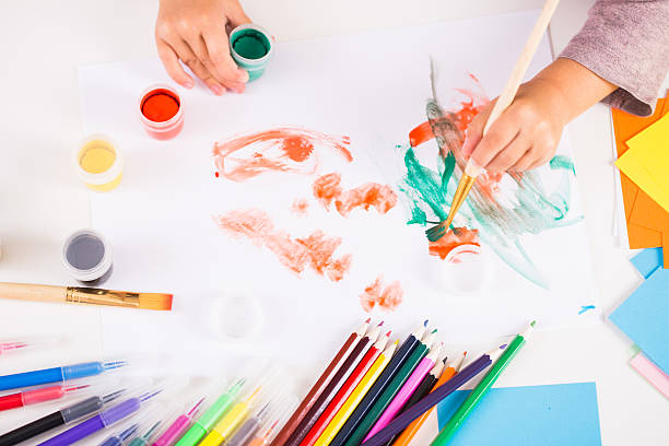 istock little girl with a brush and paints 619966726