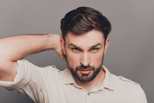 istock Handsome young brunet touching head and combining hair 619972178