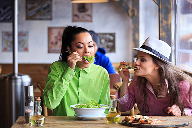 istock Two young friends having lunch in restaurant together 619973614