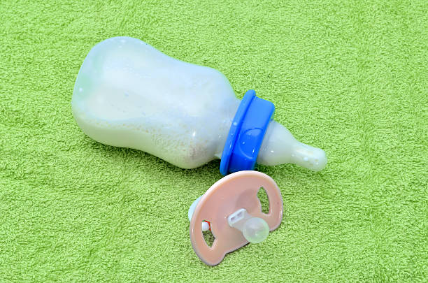 istock Pacifier and baby bottle with milk for a baby 619973694