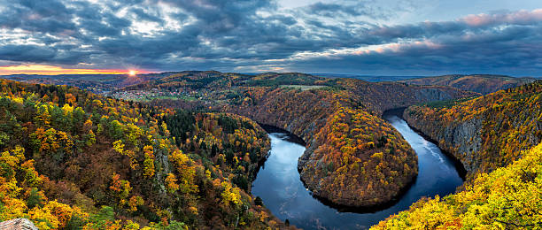 River canyon with dark water and autumn colorful forest