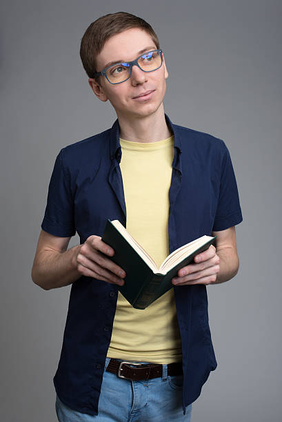istock young man in glasses reading a book 619978206
