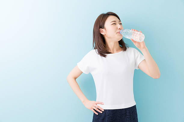 Japanese woman drinking water bottle Japanese woman drinking water bottle asian woman drinking water stock pictures, royalty-free photos & images