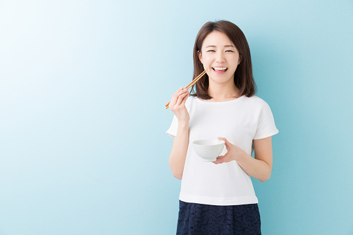 Japanese woman holding a rice bowl and chopsticks