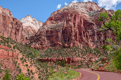 A two lane road curves among spectacular rock formations in Zion National Park.