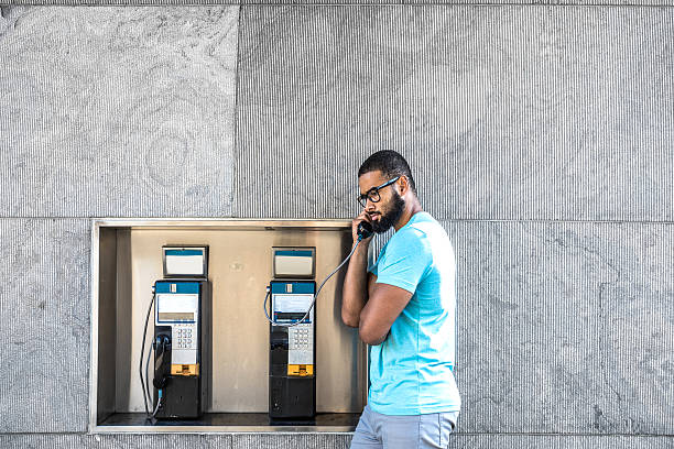 Man having a call on a phone booth in downtown