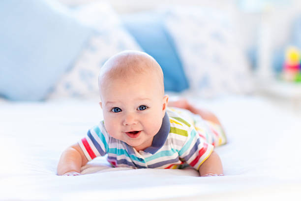 istock Baby boy in bed in sunny bedroom 619982892