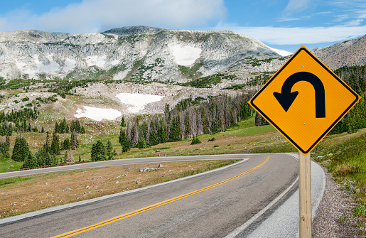 A sign warns motorists of a sharp bend ahead on a mountain road in southern Wyoming.