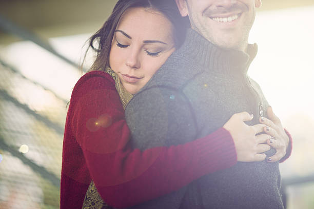 Mixed race couple embracing, smiling and enjoying
