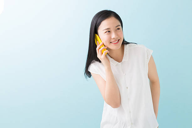 istock Japanese woman talking on a smart phone 619988600