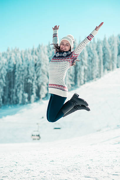 jovem feliz pulando na neve com braços levantados - on top of reaching mountain arms outstretched - fotografias e filmes do acervo