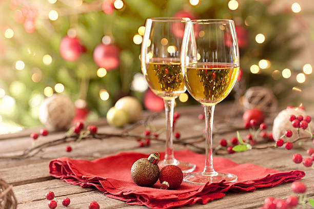 Christmas holiday white wine, old wood table, ornaments and tree