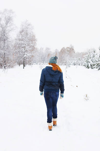 istock Slim young woman walking in a winter park 619993032
