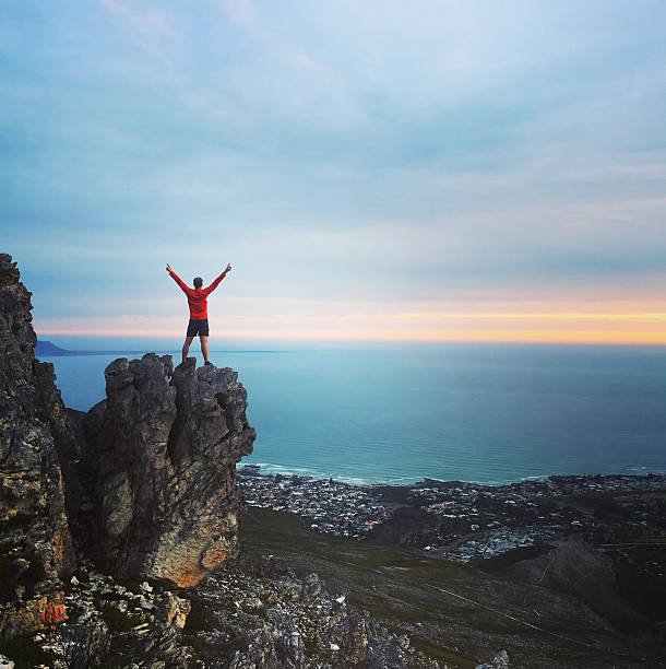 Achievement - male standing on a mountain top