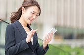 スマートフォンを持つ日本のビジネスウーマン