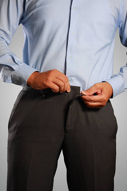 businessman dressing, pulling his pants placket - zippering imagens e fotografias de stock