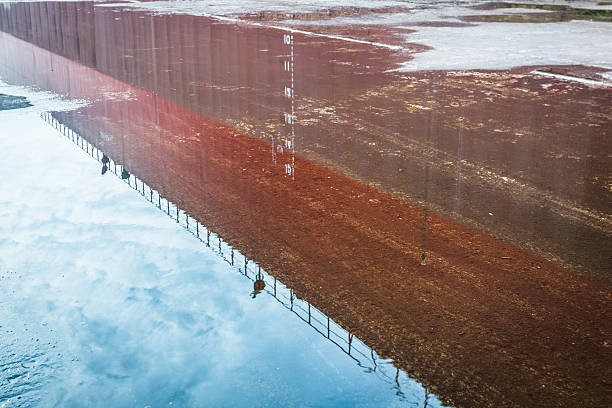 istock Reflection of building in puddle on street 619999614