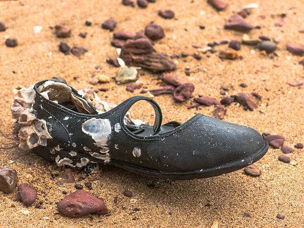istock Child Shoe Discarded Abandoned Lost Adrift Beach Concept 620000378