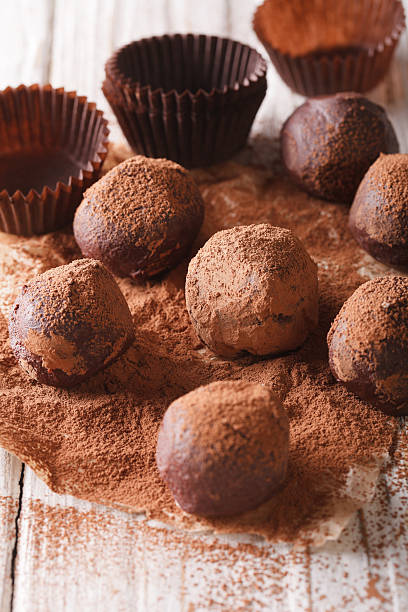 istock Chocolate truffles in cocoa macro on a wooden table. Vertical 620001154