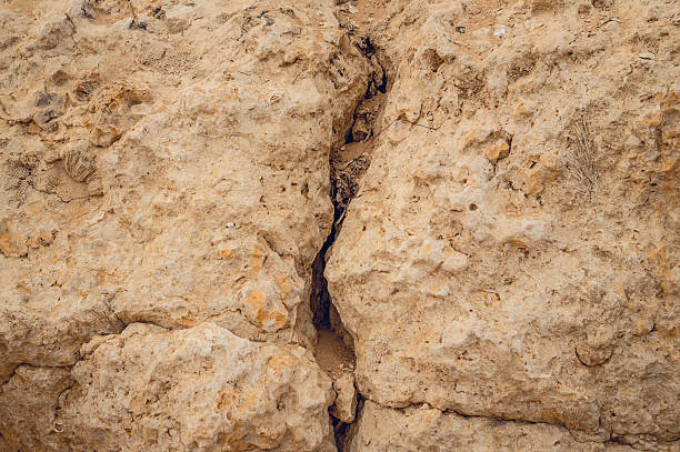 Vertical karst fissure in the monolithic stone rock. Unstable ground unsuitable for construction. A consequence of the earthquake and subsidence of the soil