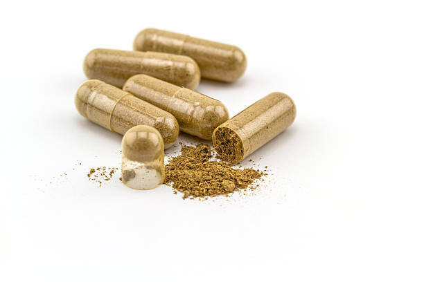 capsula e polvere di erbe su sfondo bianco. - chinese medicine herb pill nutritional supplement foto e immagini stock