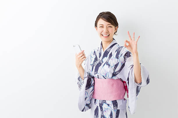 istock Woman wearing a kimono using a smartphone 620002768