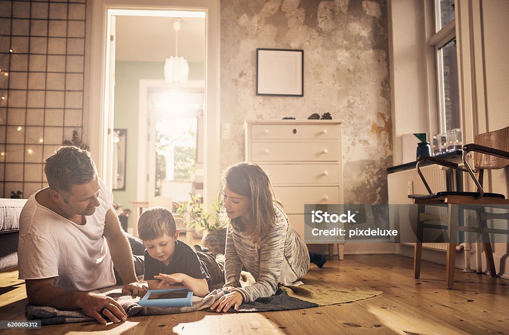 Screen time as a family Shot of a little boy and his parents using a digital tablet together at home Domestic Life Stock Photo