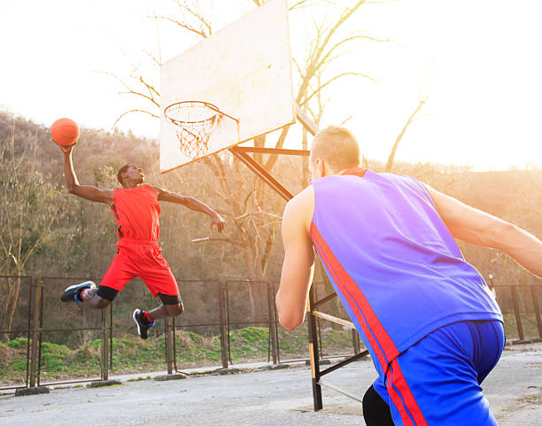 istock African basketball player slam dunking 620007666