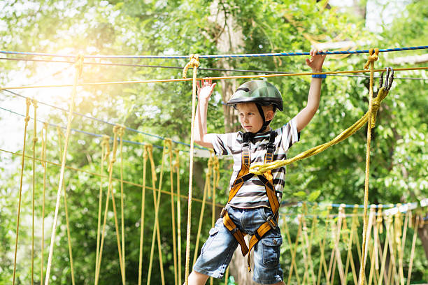 子供たちはアドベンチャーパークで登ります。 - conquering adversity endurance adventure danger ストックフォトと画像