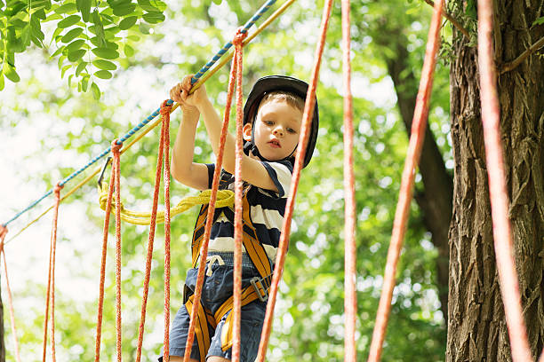 子供たちはアドベンチャーパークで登ります。 - conquering adversity endurance adventure danger ストックフォトと画像