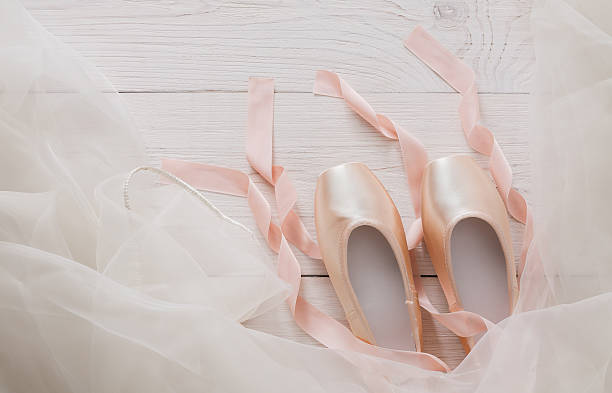 istock Pink ballet pointe shoes and tutu on white wood background 620370768