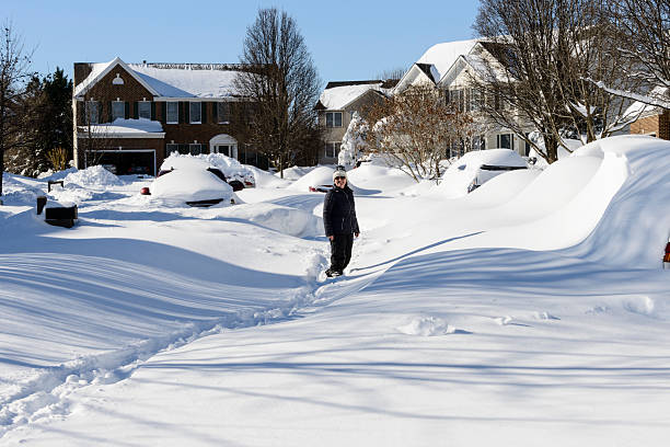 istock Woman walking through the street covered in deep snow. 620373330