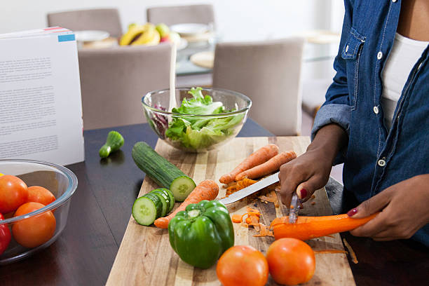 african female peeling carrots. - morning tomato lettuce vegetable imagens e fotografias de stock