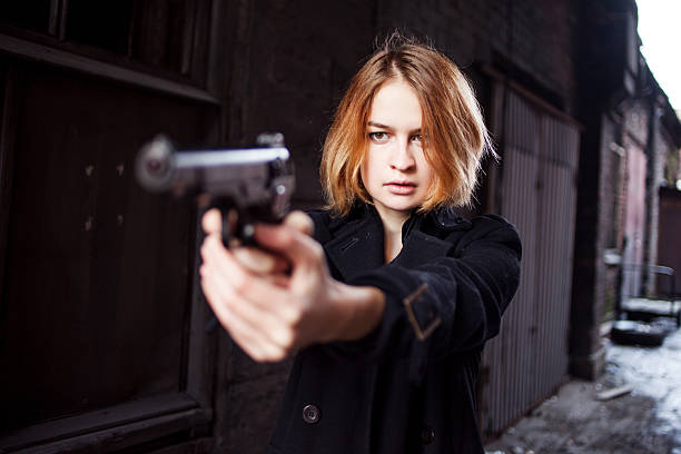 mulher apontando uma arma. garota da máfia atirando em alguém em - gun currency crime mafia - fotografias e filmes do acervo