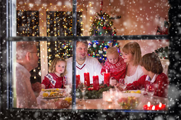 장식 된 방에서 집에서 크리스마스 저녁 식사를 즐기는 가족 - christmas dinner candle fire 뉴스 사진 이미지