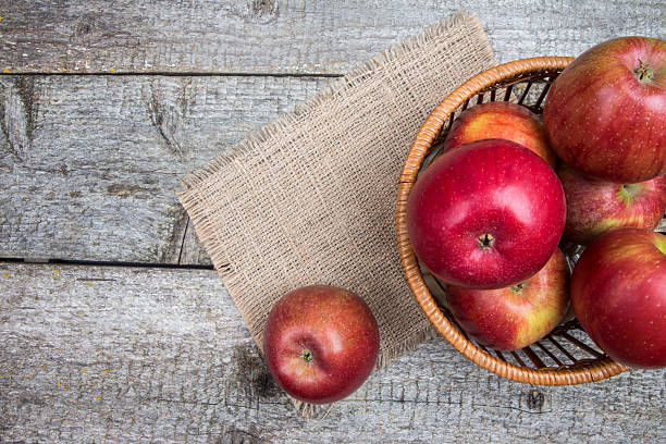 istock Apples on wooden table in wicker basket 620377720